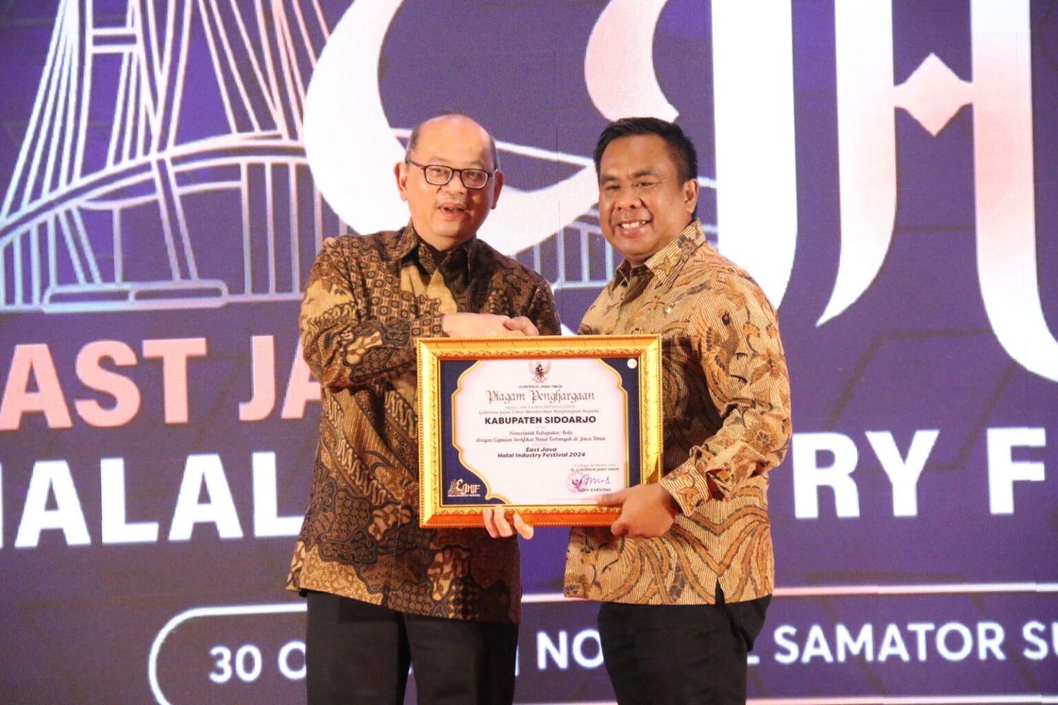 Sidoarjo Raih Penghargaan Pencapaian Sertifikat Halal Terbanyak di Jatim penghargaan diterima Pjs. Bupati Sidoarjo Muhammad Isa Anshori dari Pj. Sekda Provinsi Jawa Timur Bobby Soemiarsono dalam ajang East Java Halal Industry Festival 2024 di Hotel Novotel Samator Surabaya, Rabu (30/10/2024).