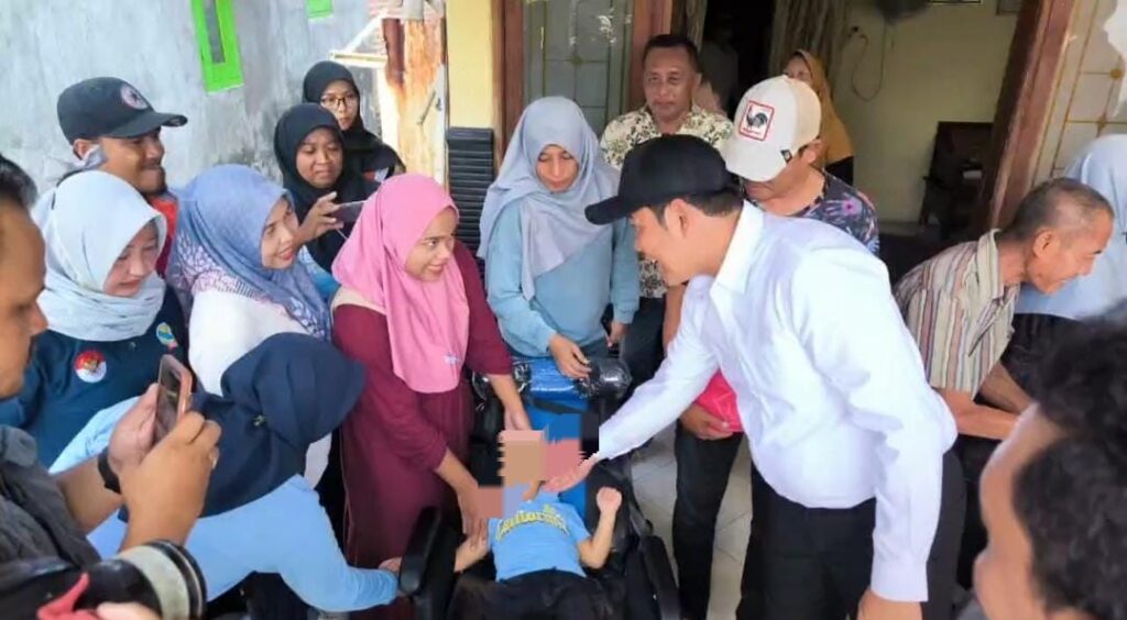 Bupati Sidoarjo Subandi bersama Kadinsos saat memberikan kursi roda kepada bocah (2'5) tahun Muhammad Abhinara Alfarizqi di Kecamatan Tarik Kabupaten Sidoarjo, Sabtu (2/5/2026),(foto: Dian).