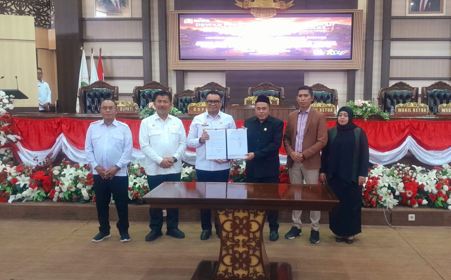 Bupati Kutai Kartanegara Aulia Rahman Basri bersama pimpinan DPRD Kukar menunjukkan dokumen hasil persetujuan bersama Perubahan APBD Kukar Tahun Anggaran 2026 usai rapat paripurna di Gedung DPRD Kukar, Rabu (30/9/2026).